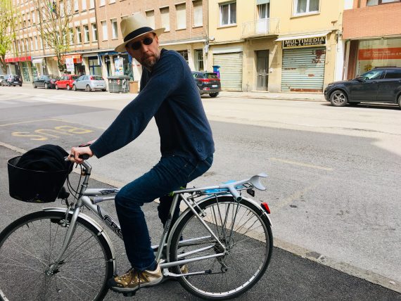 Greg on bike with dapper hat.