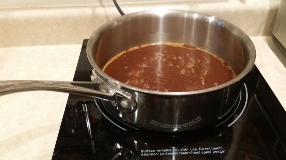 Sauce from the fridge is defatted and heating up, reducing a bit.